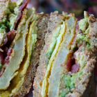 Fried Green Tomato Egg Sandwiches with Applewood Smoked Bacon, Avocado, Cheddar, and Spicy Aioli