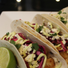 Beer Battered Fish Tacos with Cilantro Lime Red Cabbage Slaw, Avocado Crema, and Cotija Cheese
