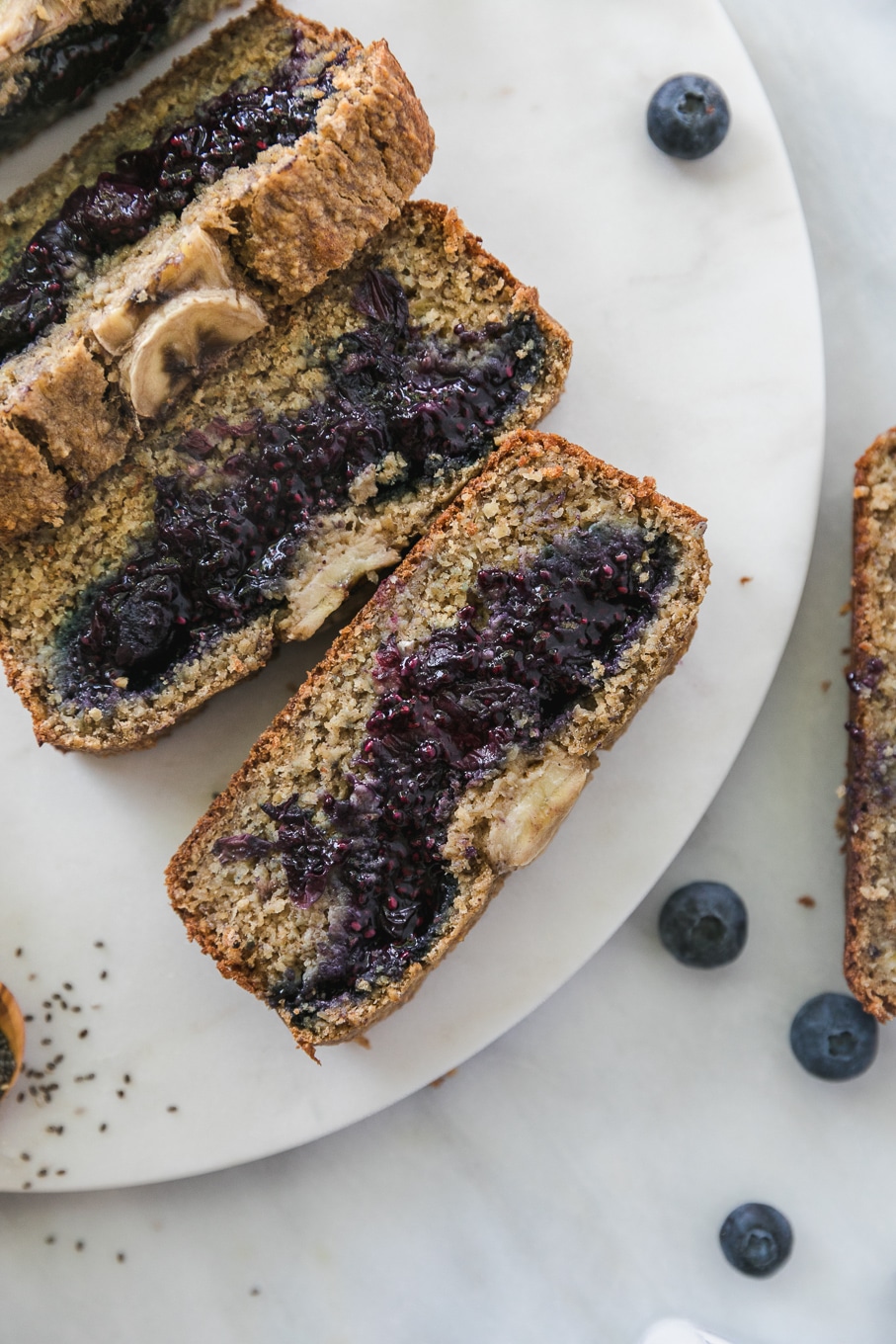 Overhead shot of a loaf of blueberry chia jam stuffed banana bread with 3 slices cut off