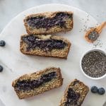 Overhead shot of slices of blueberry chia jam stuffed banana bread on a circular marble board
