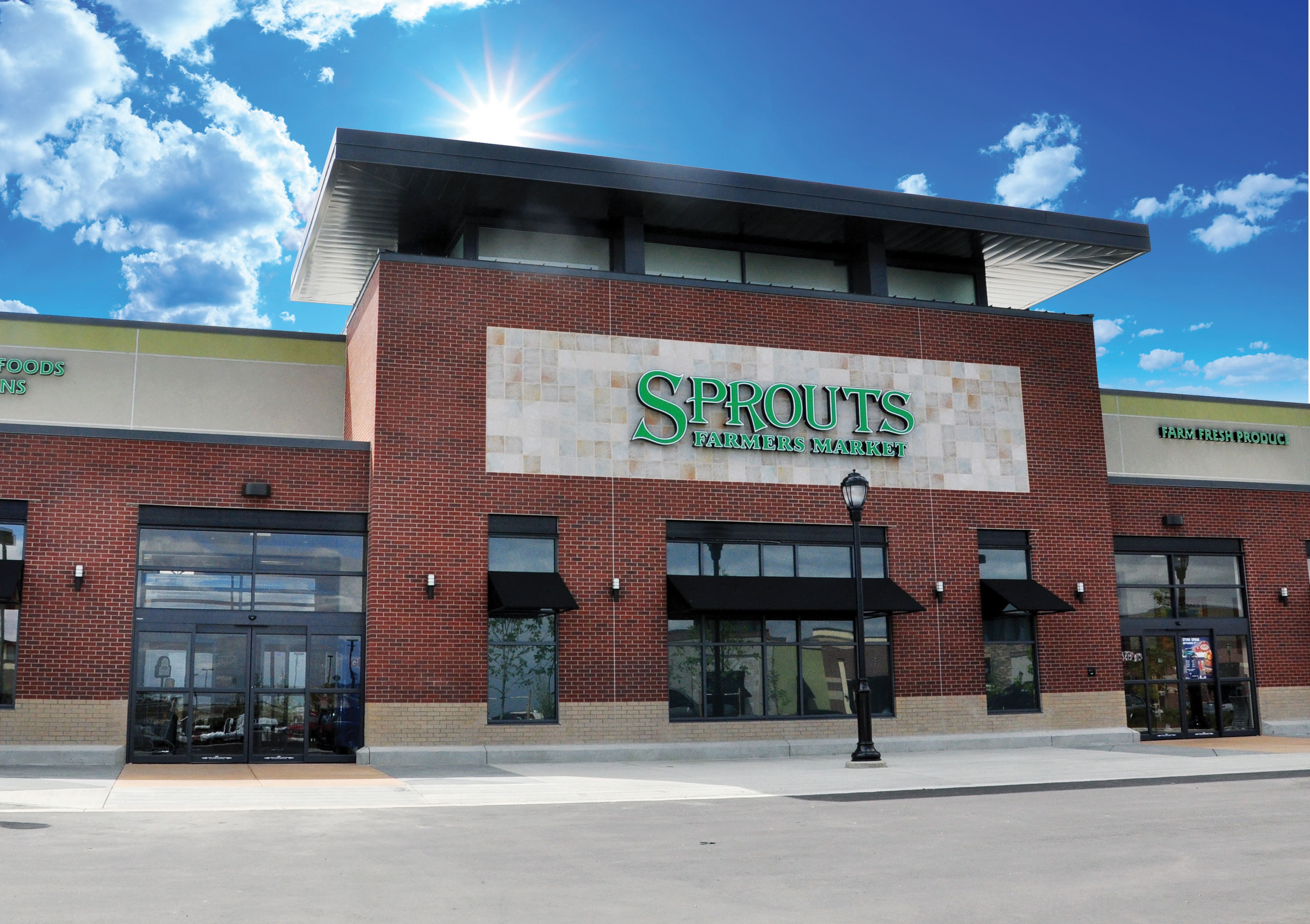 Photo of a storefront of a Sprouts Farmers Market Store against a blue, sunny sky