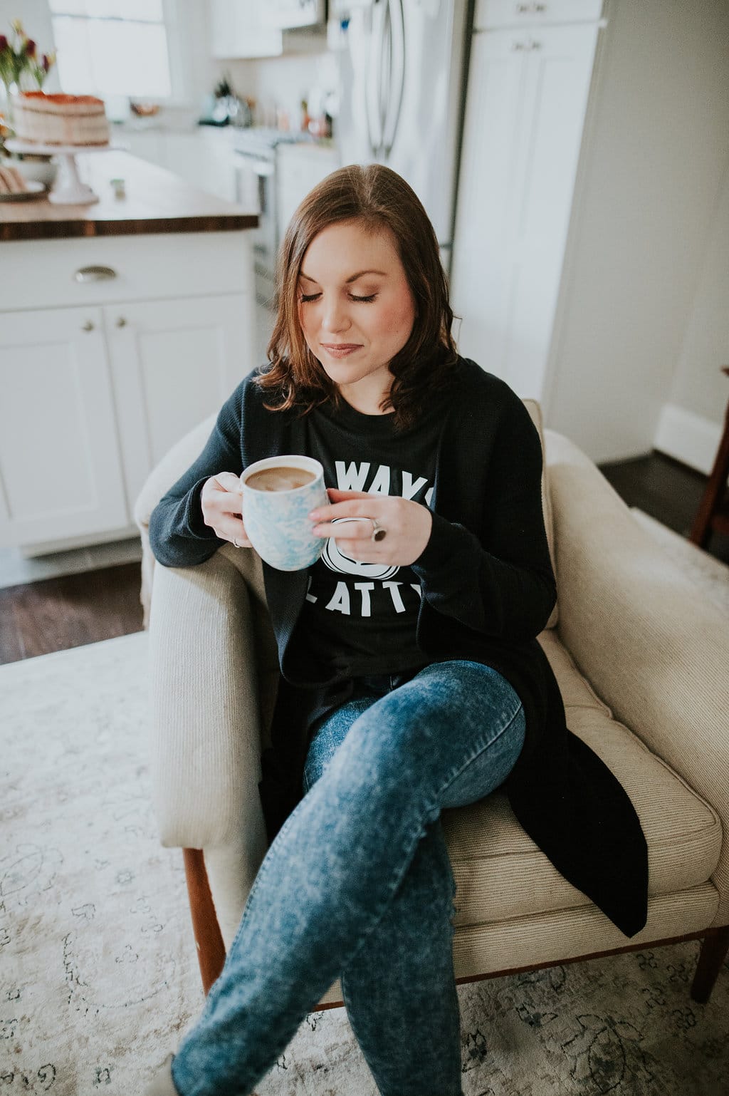 Shot of woman sitting in a living room holding a cup of coffee