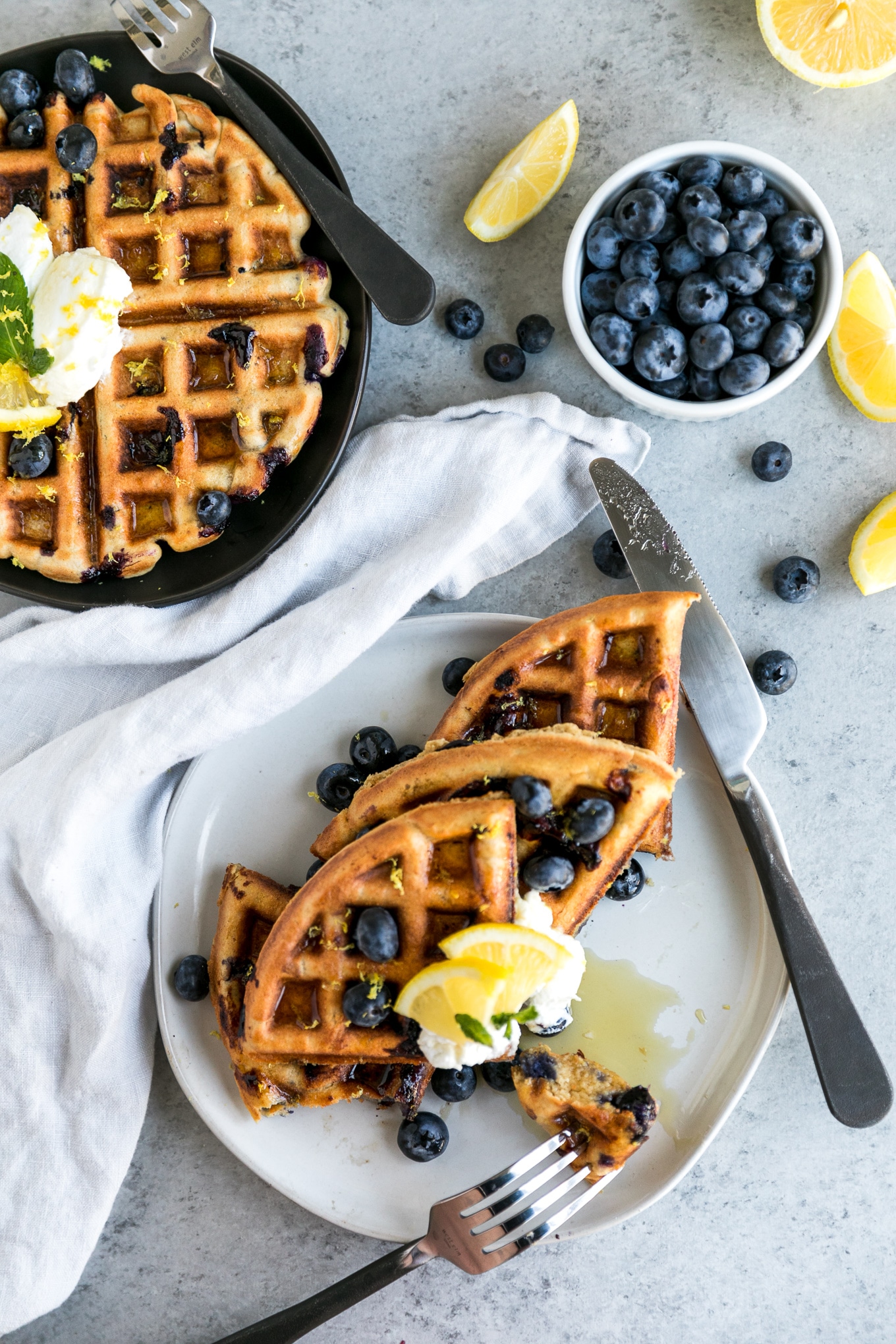 waffles topped with blueberries, lemon slices, and a dollop of