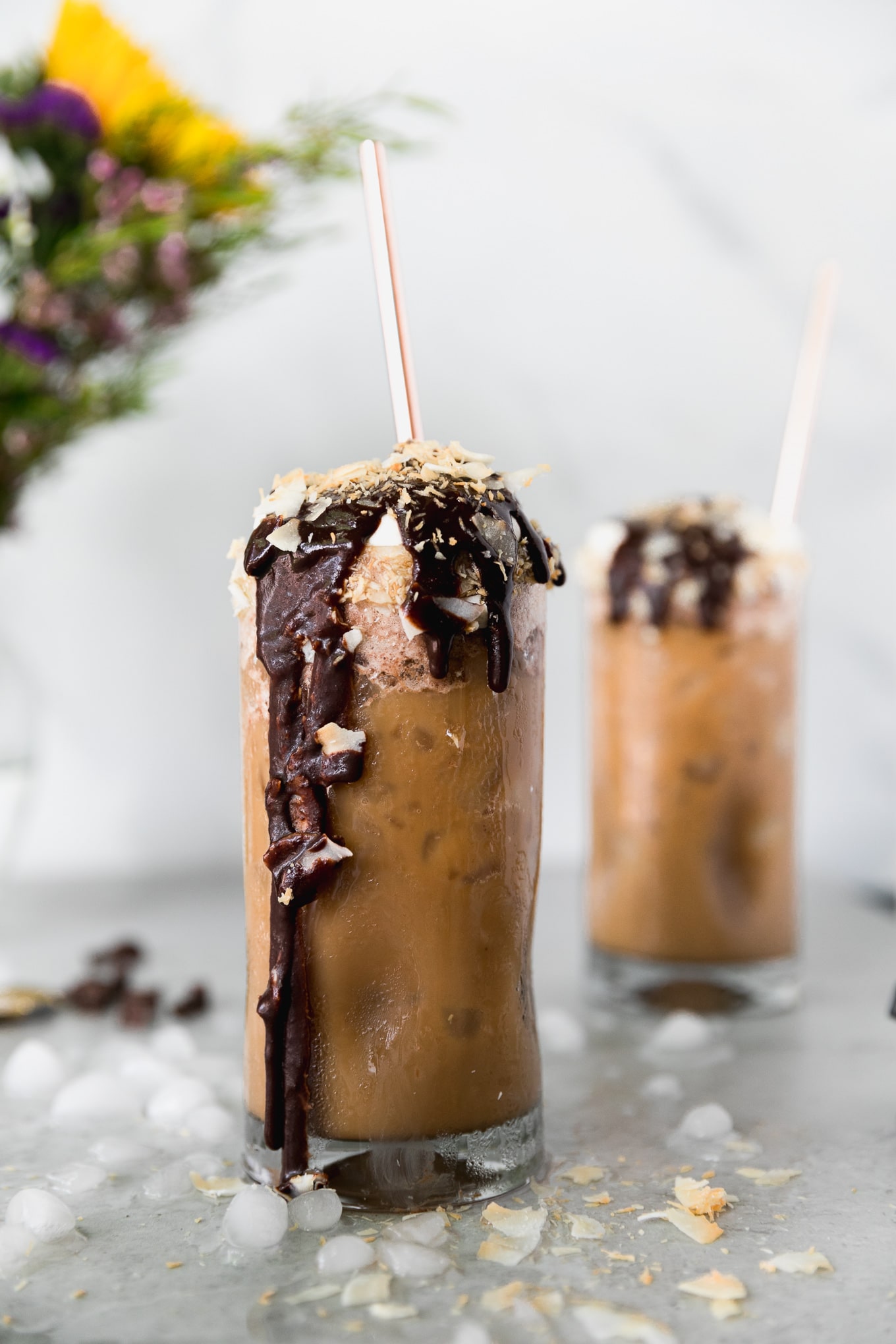 Forward facing shot of an iced coffee with lots of chocolate sauce dripping down the glass