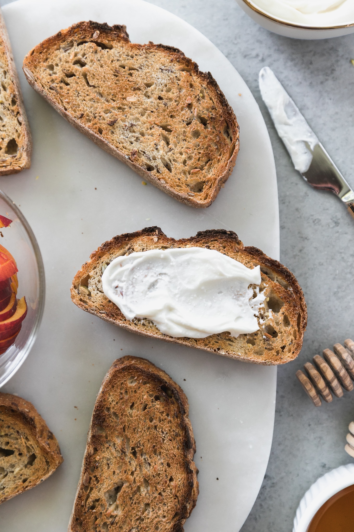 Overhead close up shot of several pieces of toast, with ricotta spread on one of the pieces 