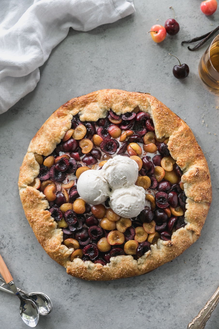 Overhead shot of a cherry galette with 3 scoops of ice cream on top