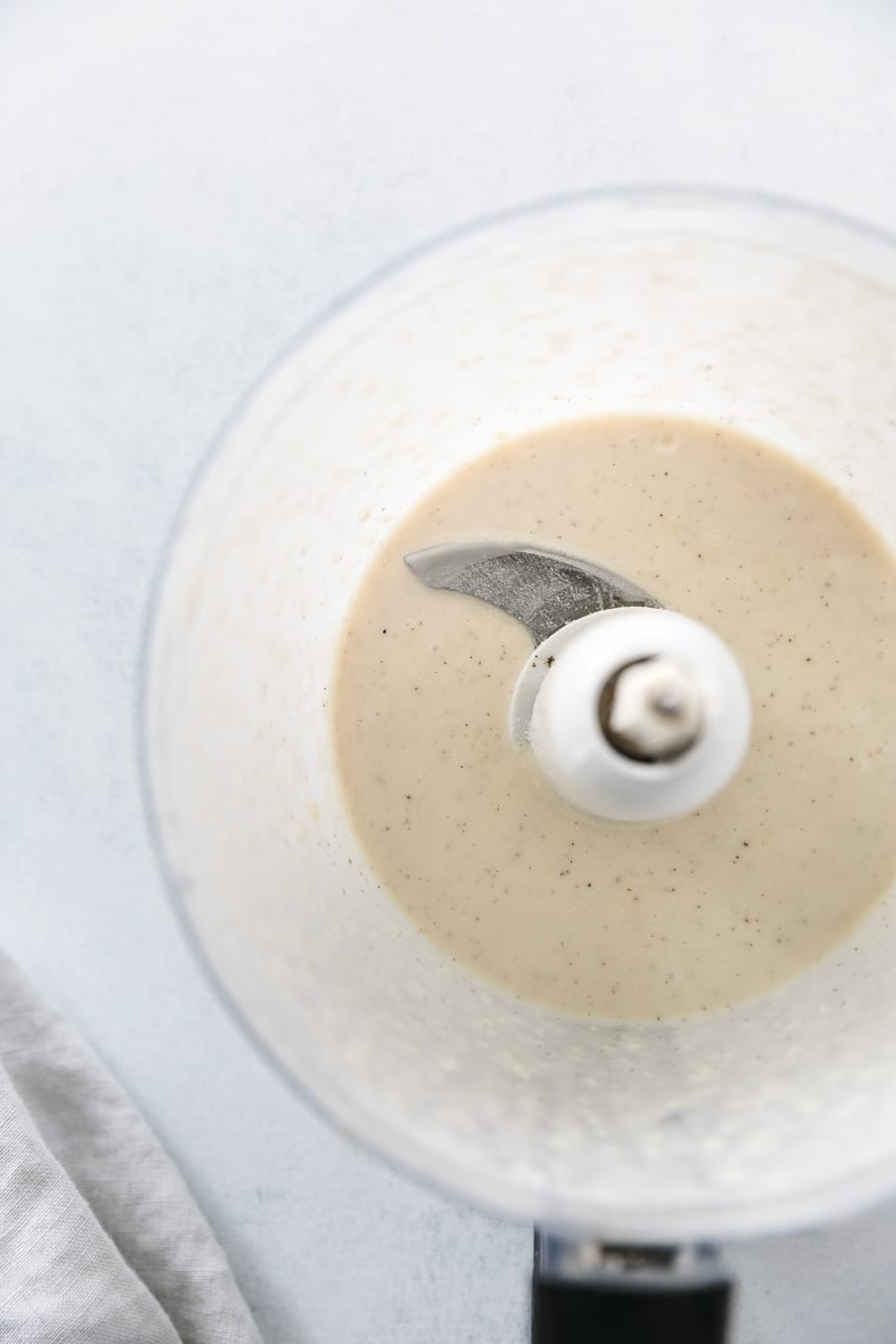 Overhead shot of a food processor filled with creamy parmesan garlic dressing