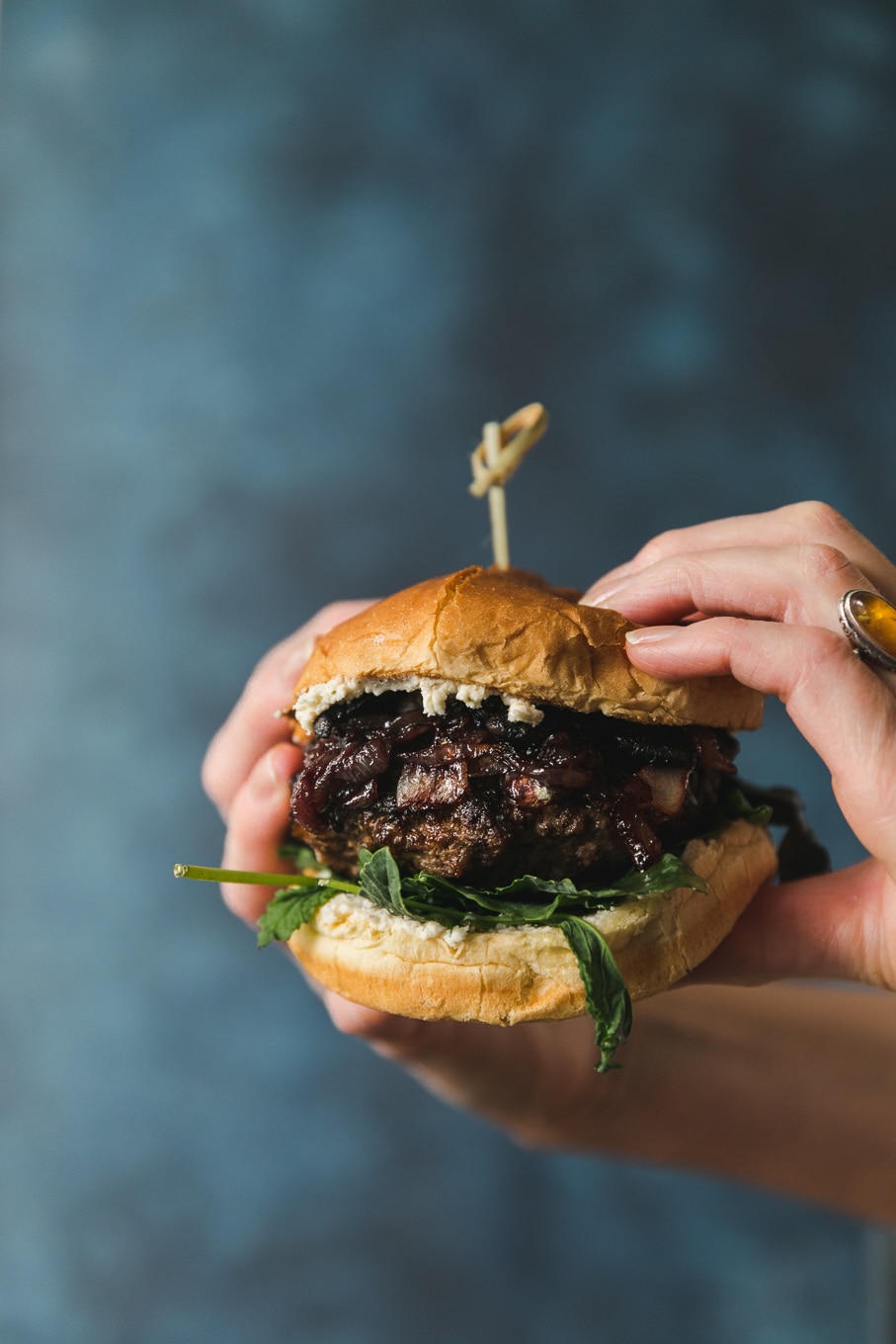 Close up forward facing shot of hands holding a burger