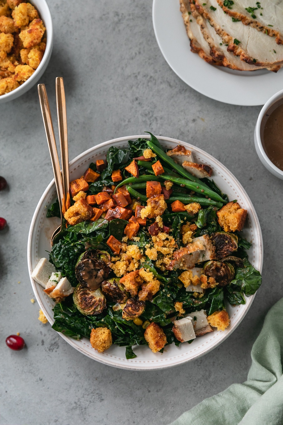 Overhead shot of a thanksgiving leftovers kale salad with roasted sweet potatoes, brussels, green beans, and cornbread croutons