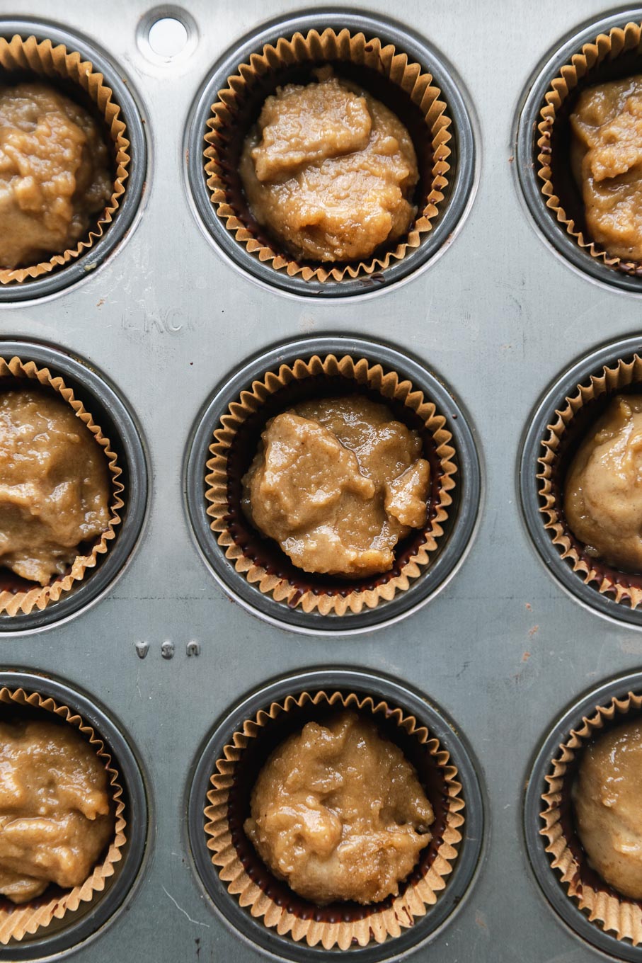 Overhead shot of a mini muffin tin filled with dark chocolate and tahini filling