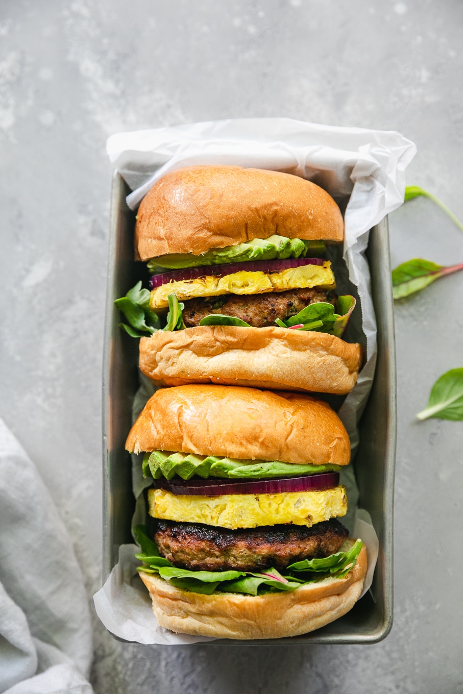 Overhead shot of a rectangle loaf pan with two burgers in it