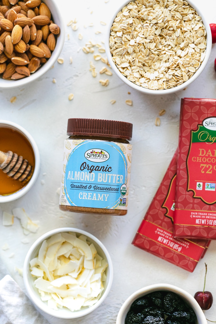 Overhead shot of oats, almond butter, chocolate, coconut, honey, and almonds