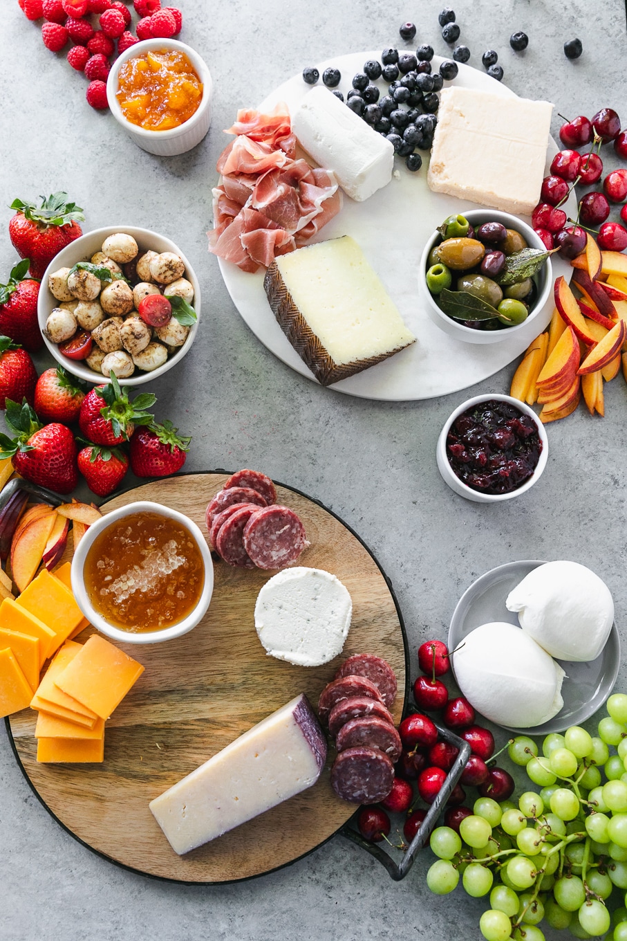 Overhead shot of cheeses, salami, and fruit