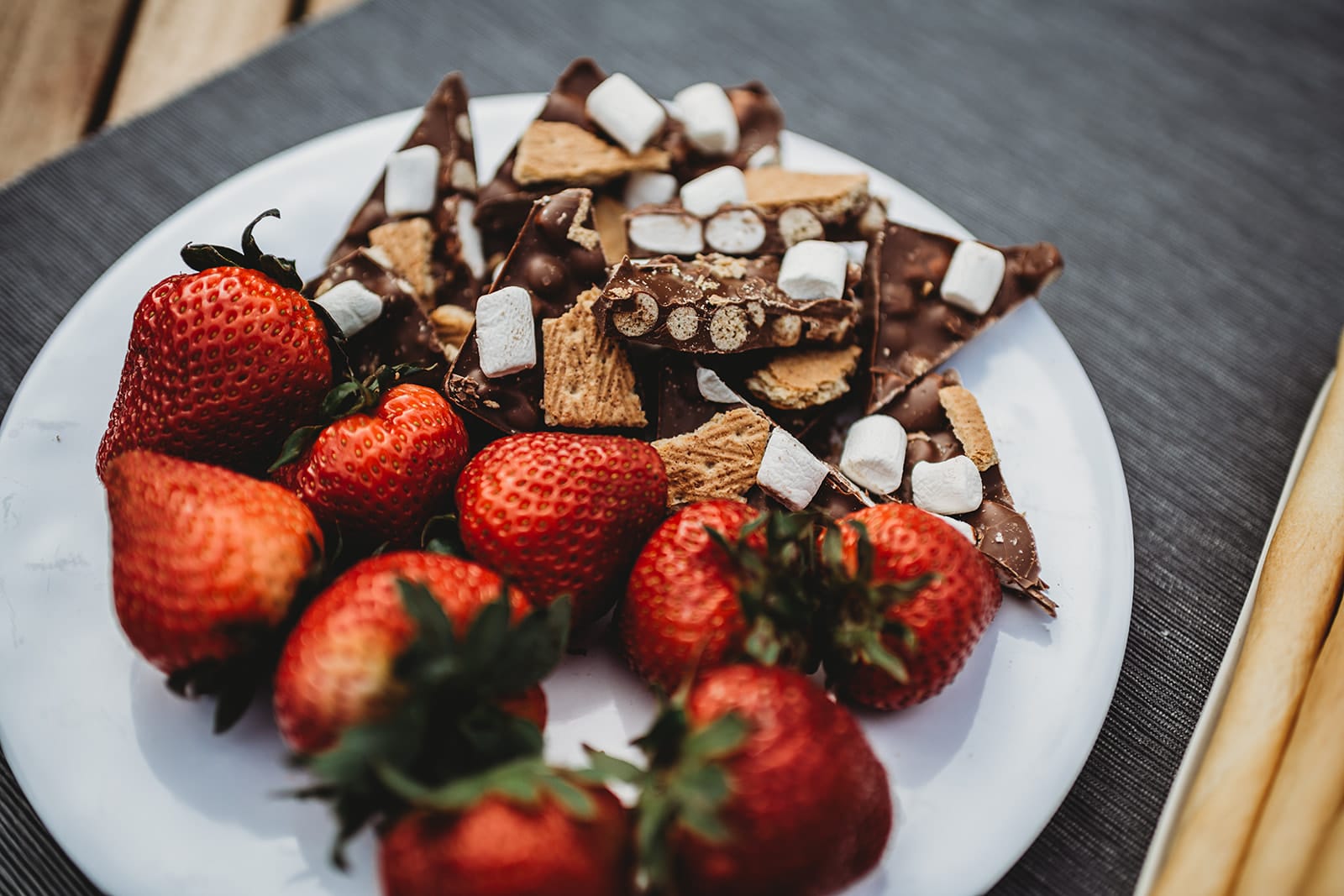 close up shot of a plate of strawberries and s'mores chocolate