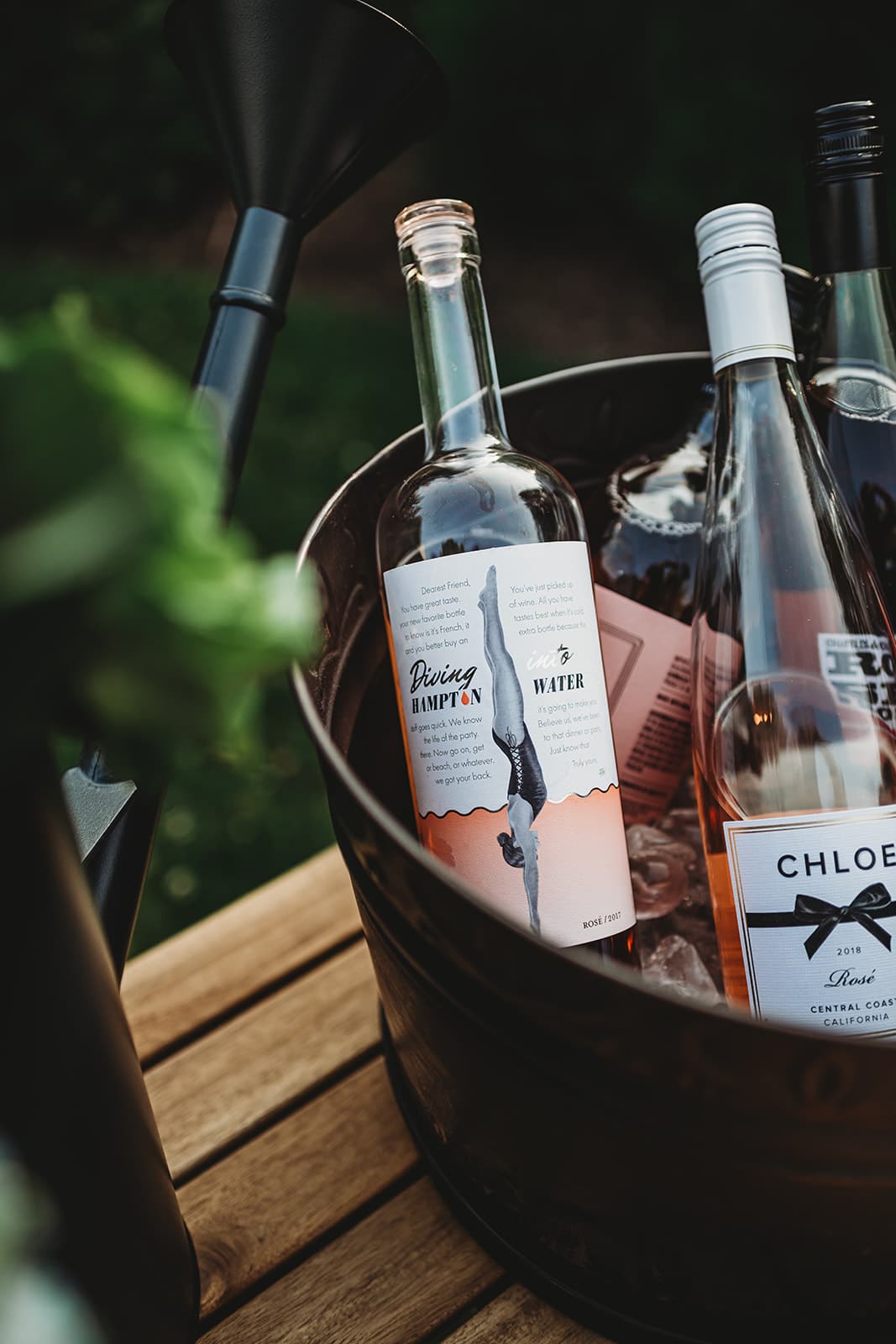 Close up shot of a bucket filled with bottles of rosé