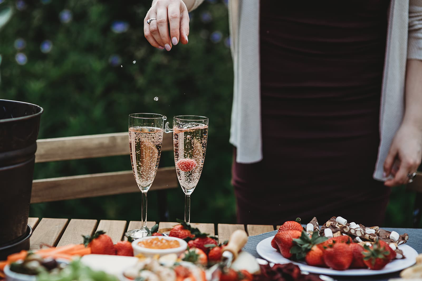 Shot of someone dropping strawberries into glasses of champagne