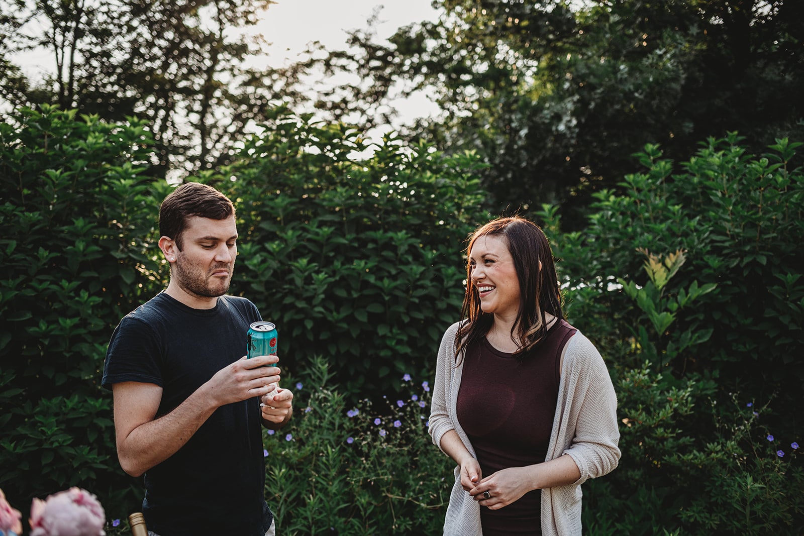 Shot of a woman and a man laughing in a garden