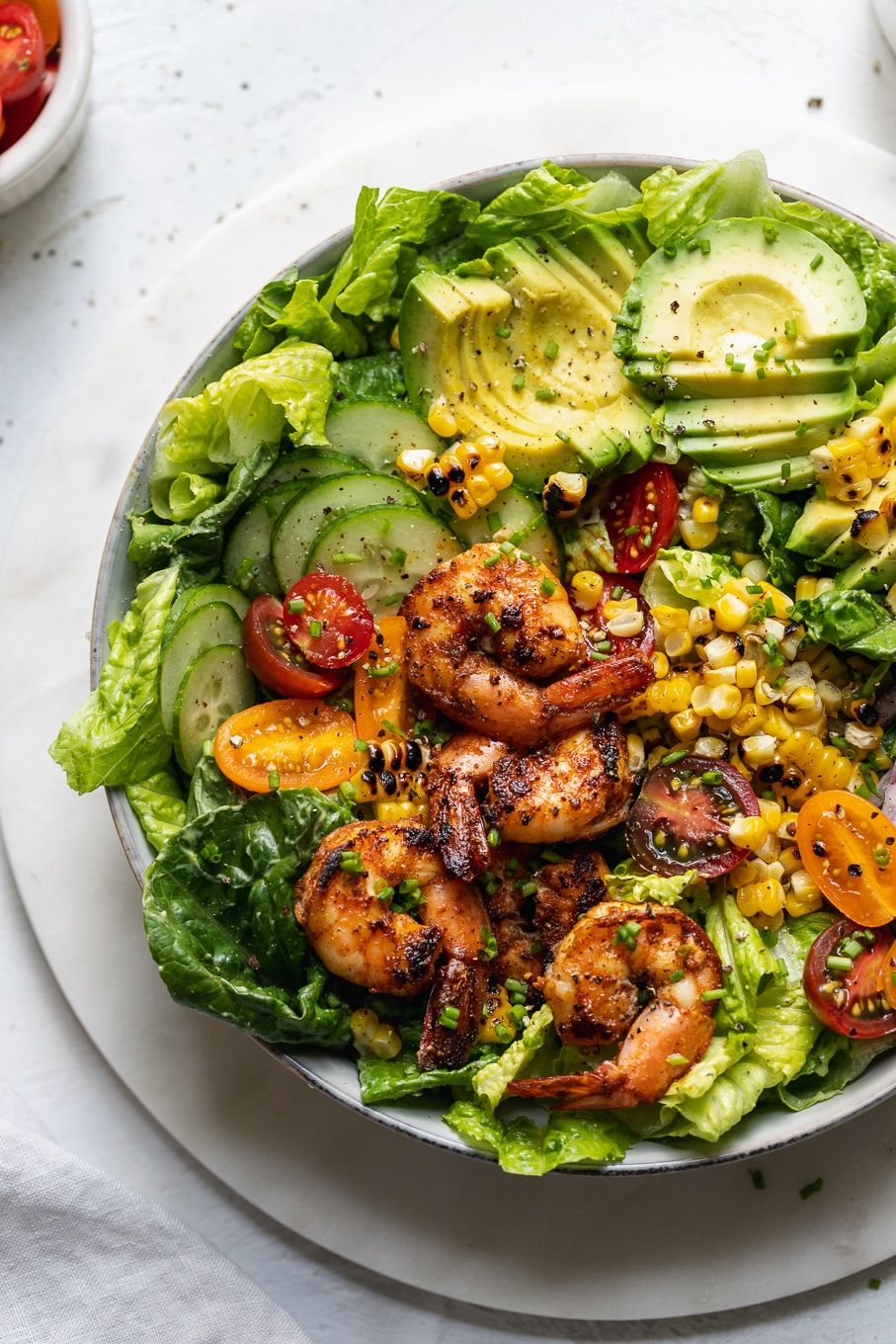 Overhead shot of a colorful blackened shrimp salad with tomatoes and avocado