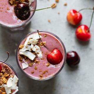 Overhead shot of 3 cherry smoothies topped with coconut and granola