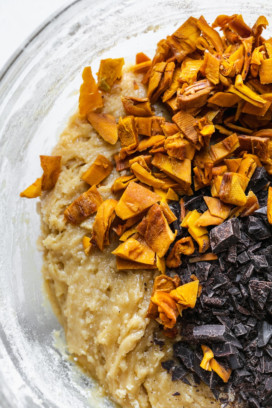 Overhead shot of cookie dough with chopped mango and dark chocolate on top