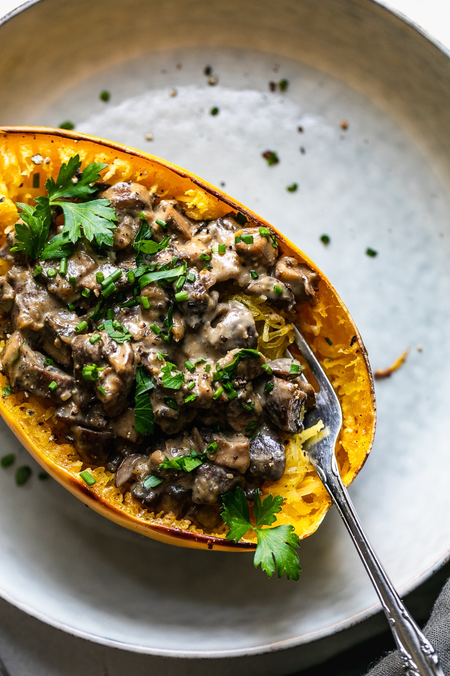 Overhead close up shot of a creamy mushroom spaghetti squash boat with a fork digging in