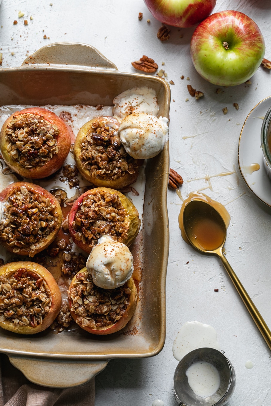 Overhead shot of a casserole dish filled with baked apples and ice cream scoops