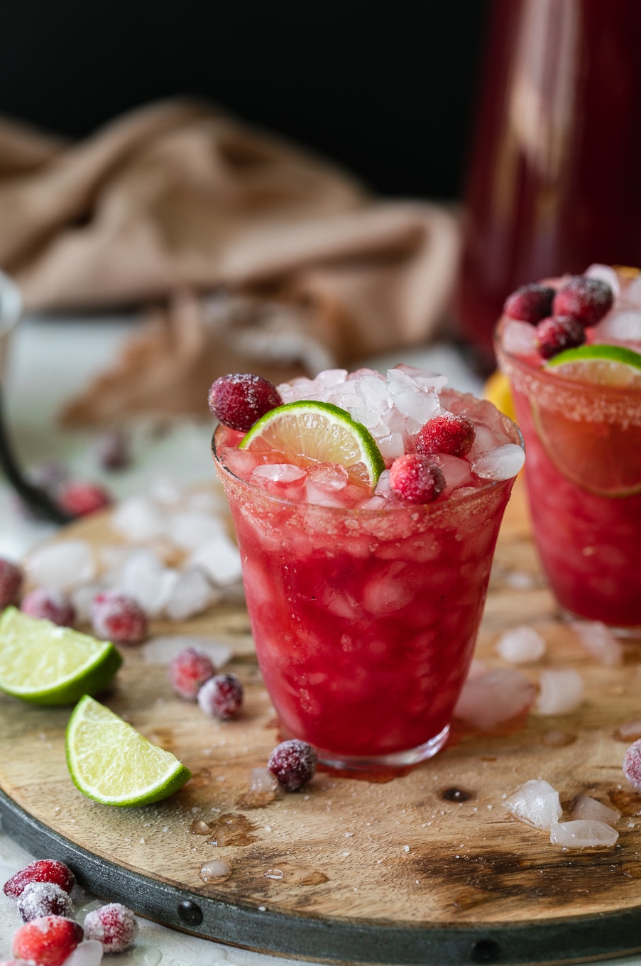 Close up shot of a cranberry margarita tarnished with lime and sugared cranberries