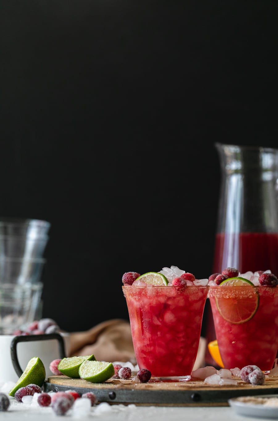 Straight on shot of two cranberry margaritas against a black background