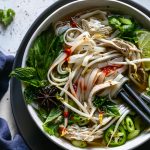 Overhead shot of a colorful bowl of pho with chopsticks in the bowl