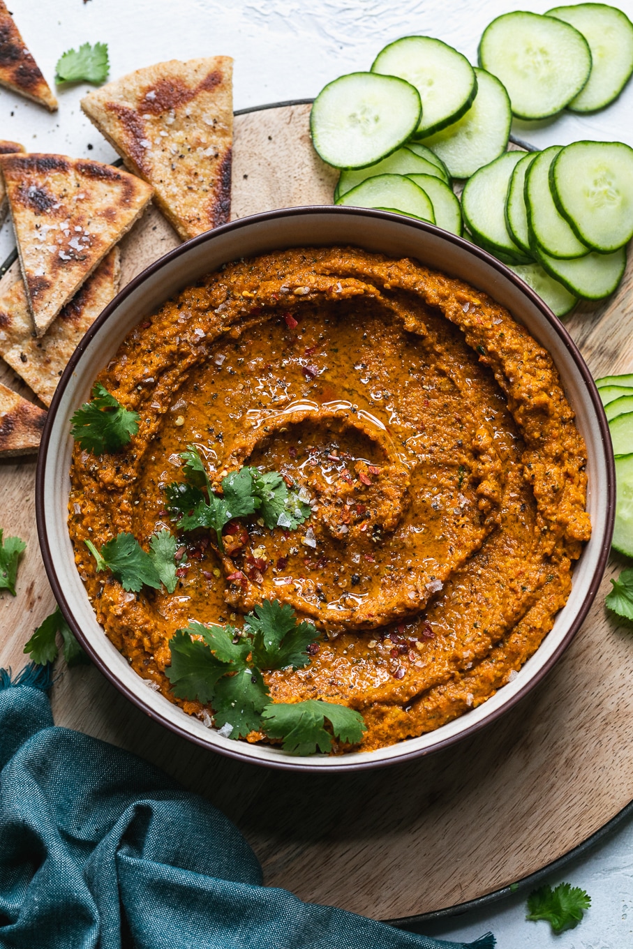 Overhead shot of a bowl of carrot dip garnished with cilantro