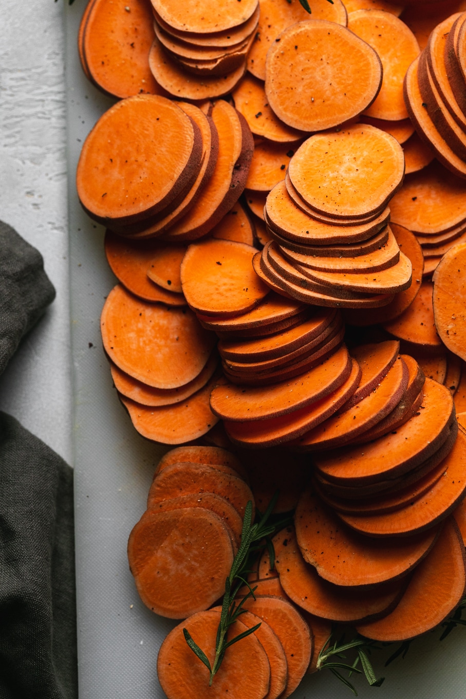 Overhead shot of a pile of thinly sliced sweet potatoes