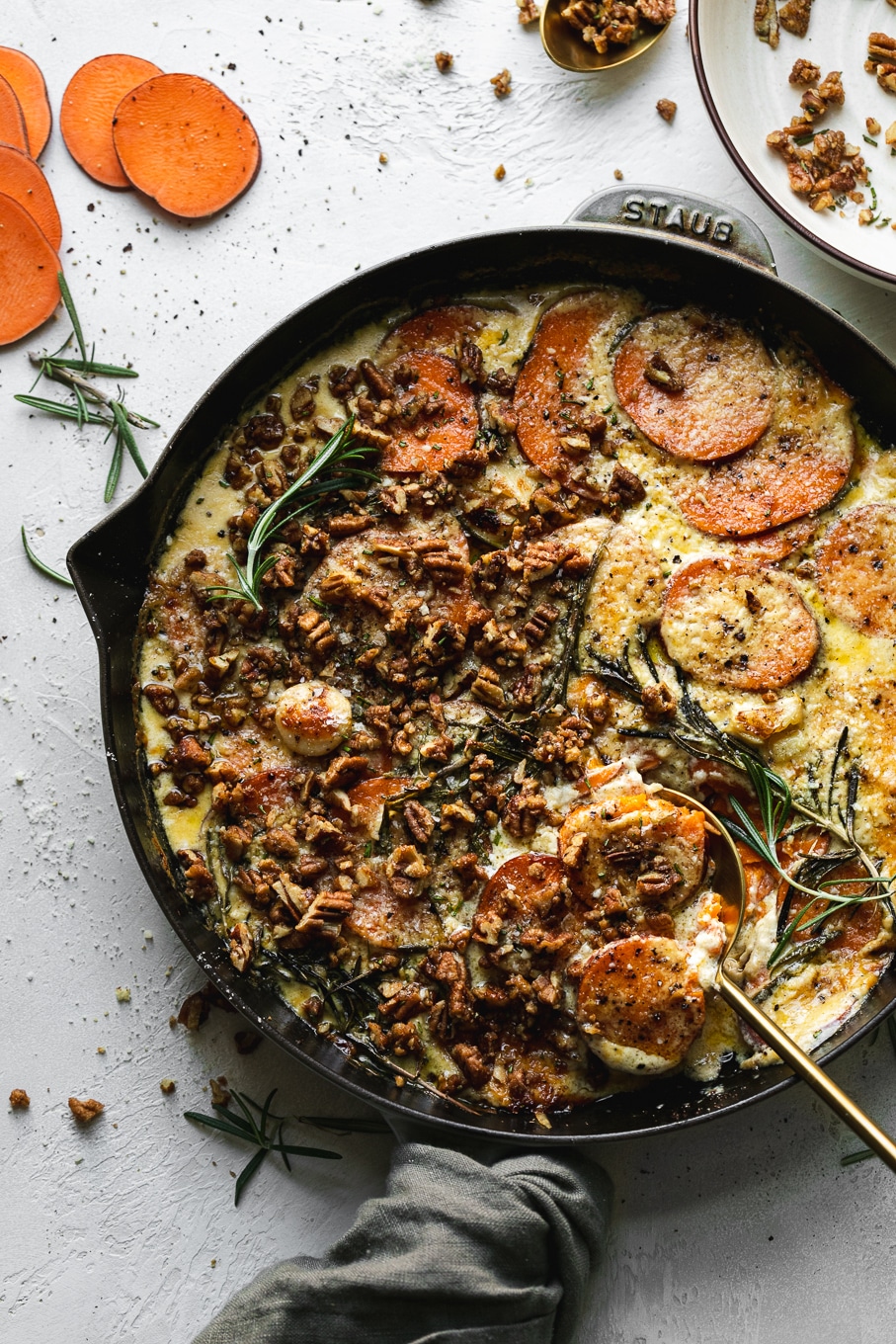 Overhead shot of sweet potato gratin after baking with rosemary pecan crunch on top