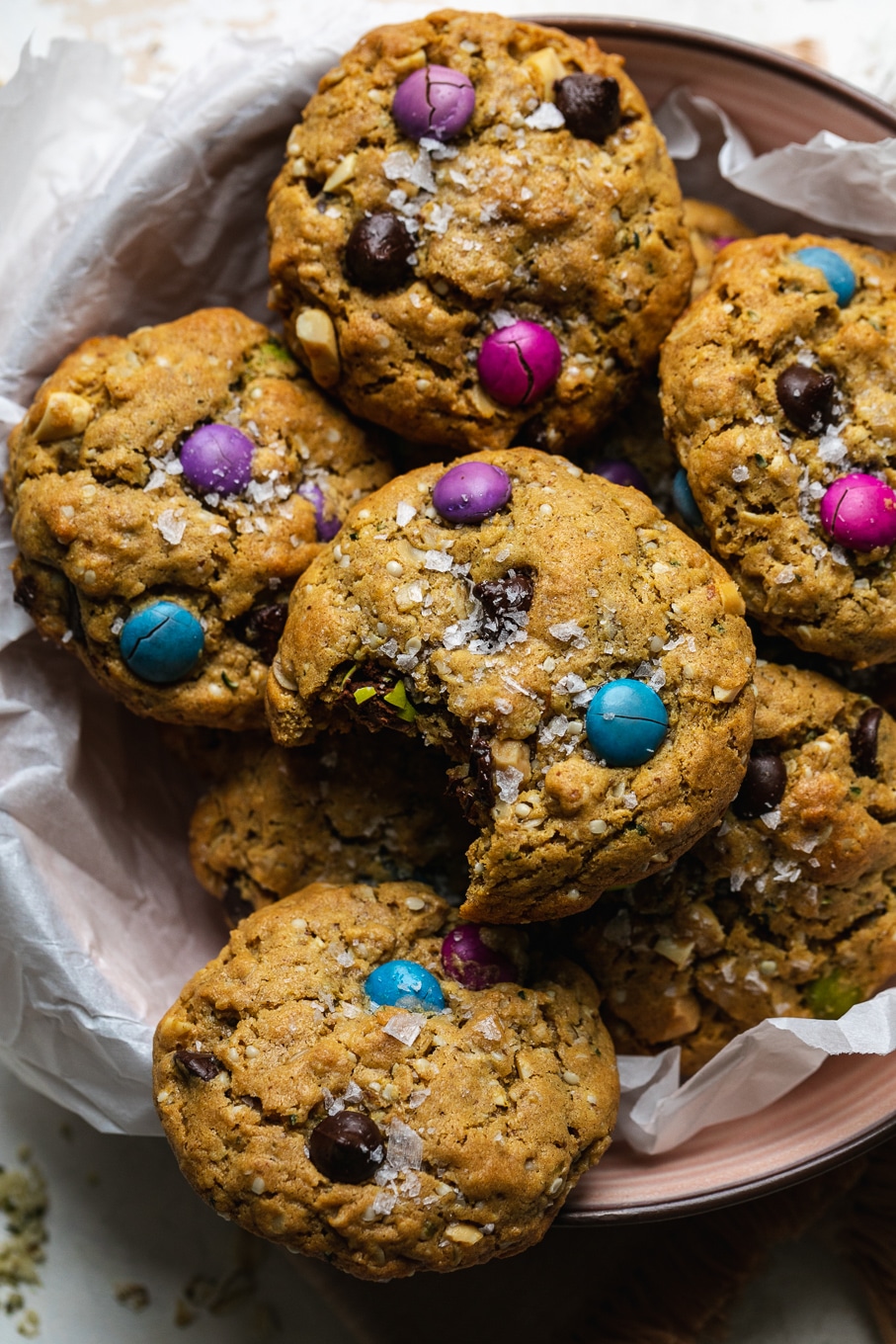 Close up shot of a pile of monster cookies with a bite taken out on top