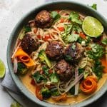 Overhead shot of a bowl of rice noodle stir fry with meatballs