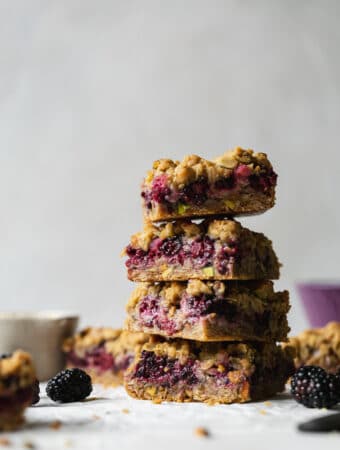 Straight on shot of a stack of blackberry pistachio crumble bars